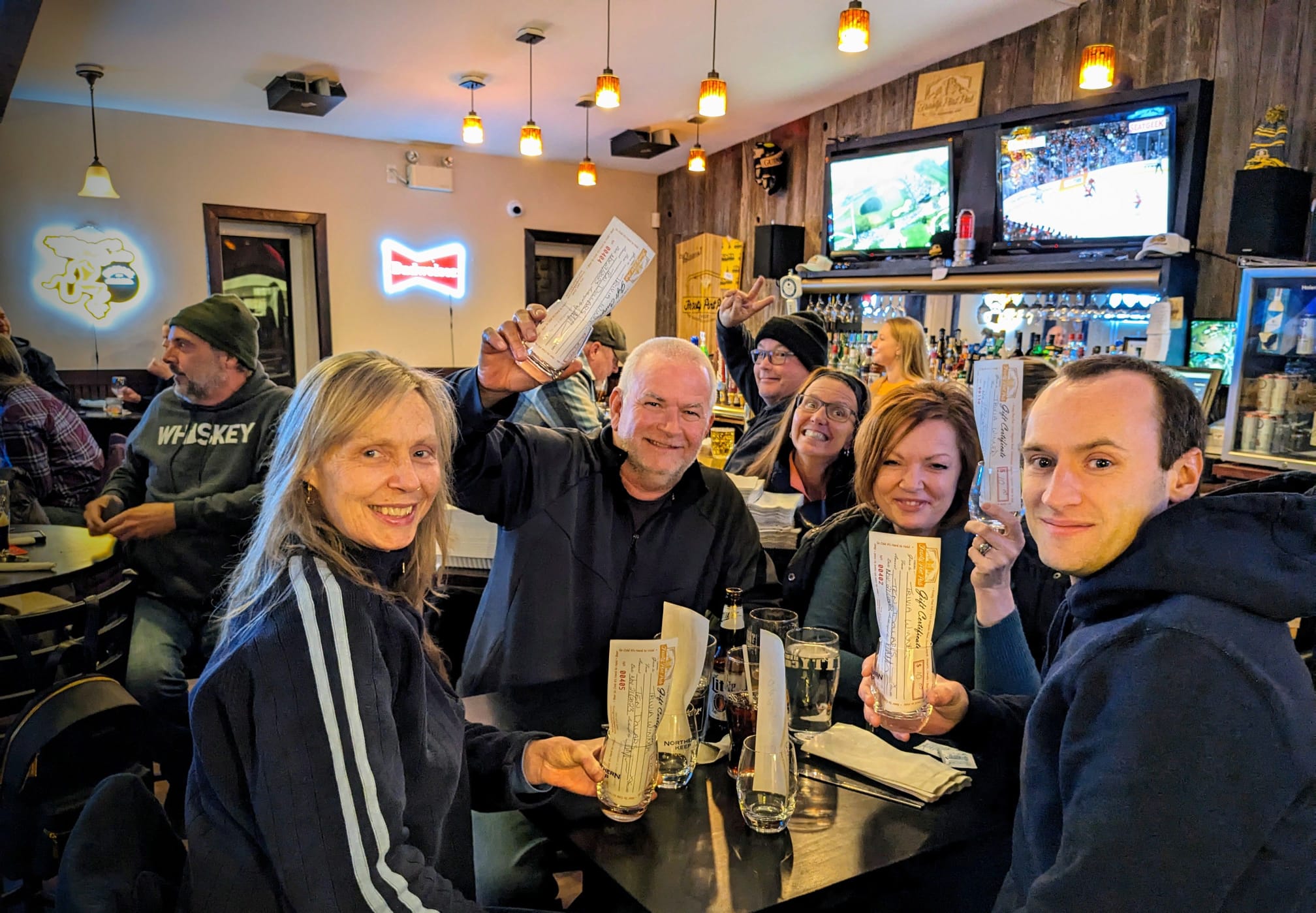 Friends celebrating with gift certificates at bar trivia night